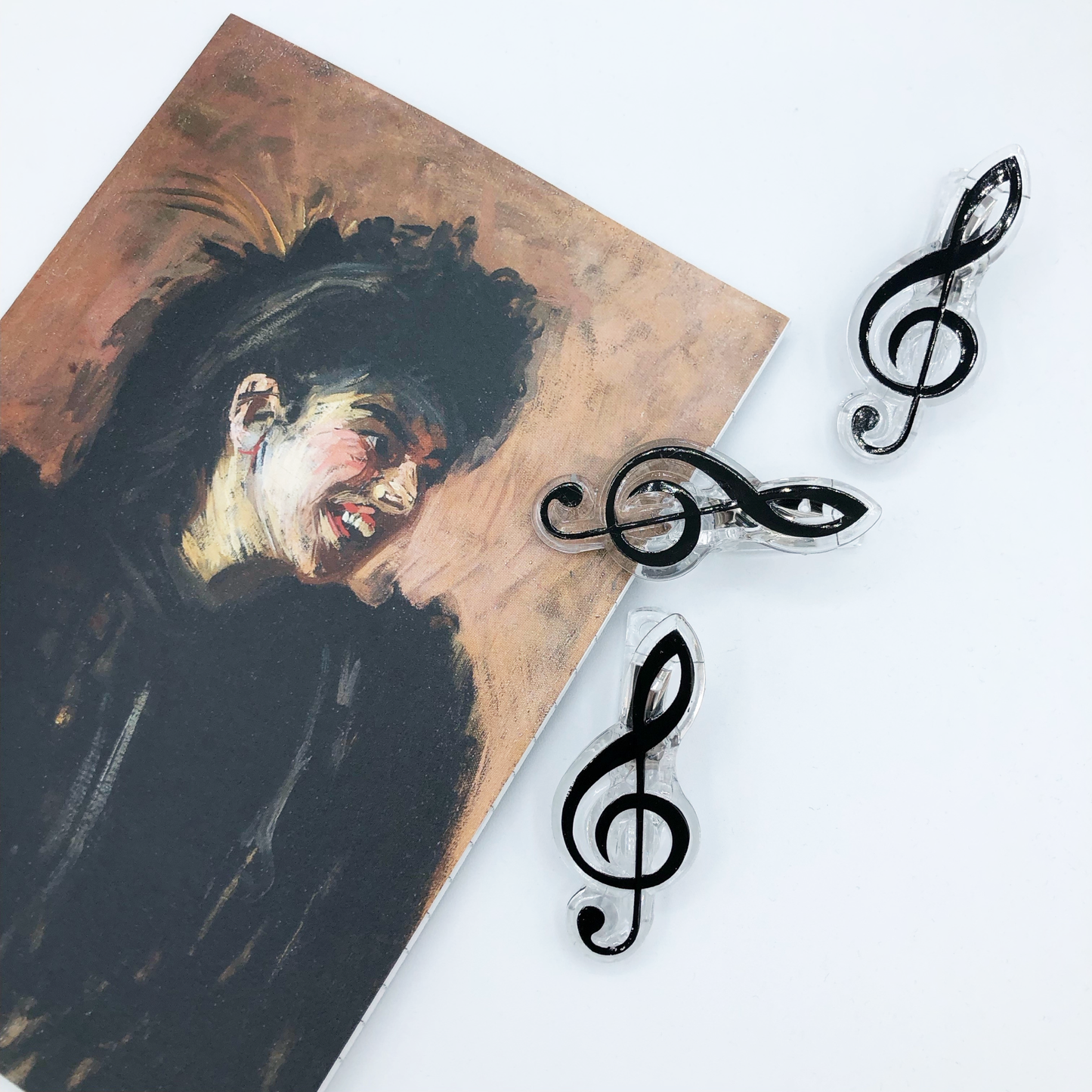Notebook featuring the painting 'Blackbird of Paradise' with music note clips, on a white background.