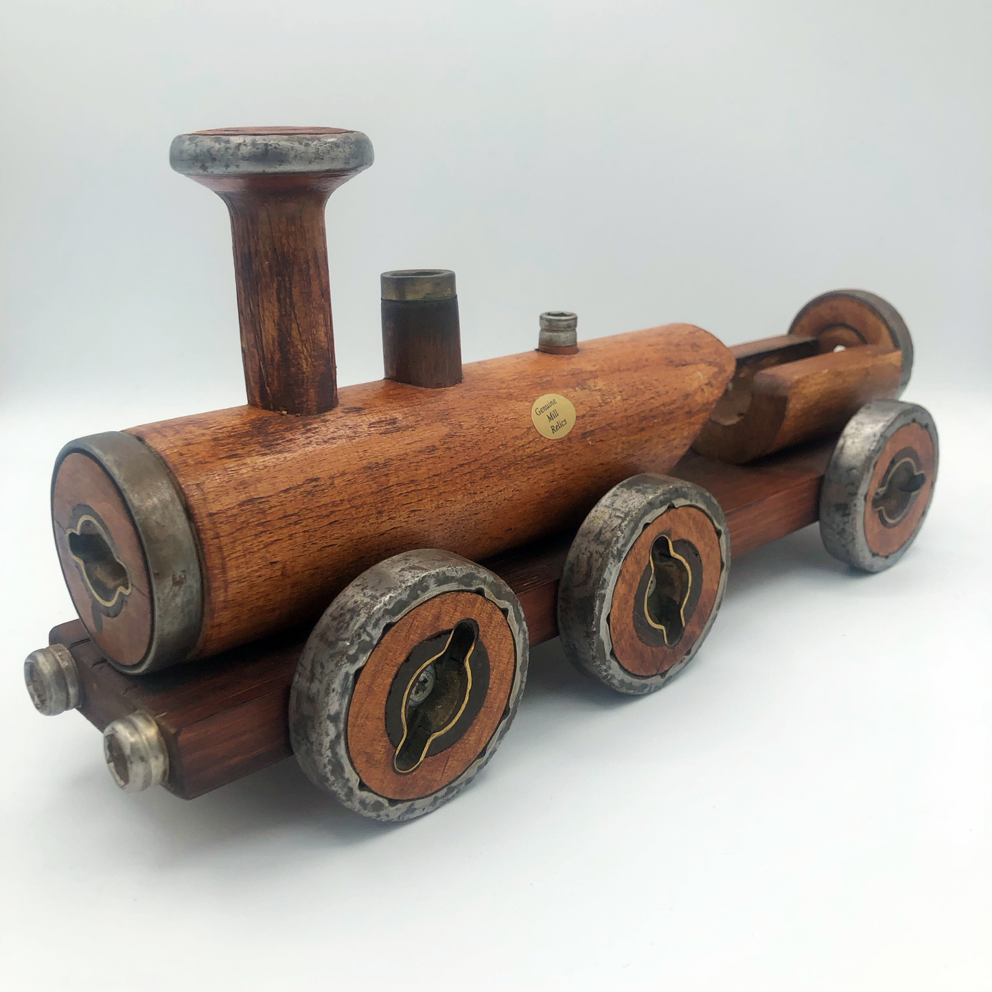 A wooden train ornament with metal accents made from recycled bobbins, resembling a steam train with a brown body and grey wheels.