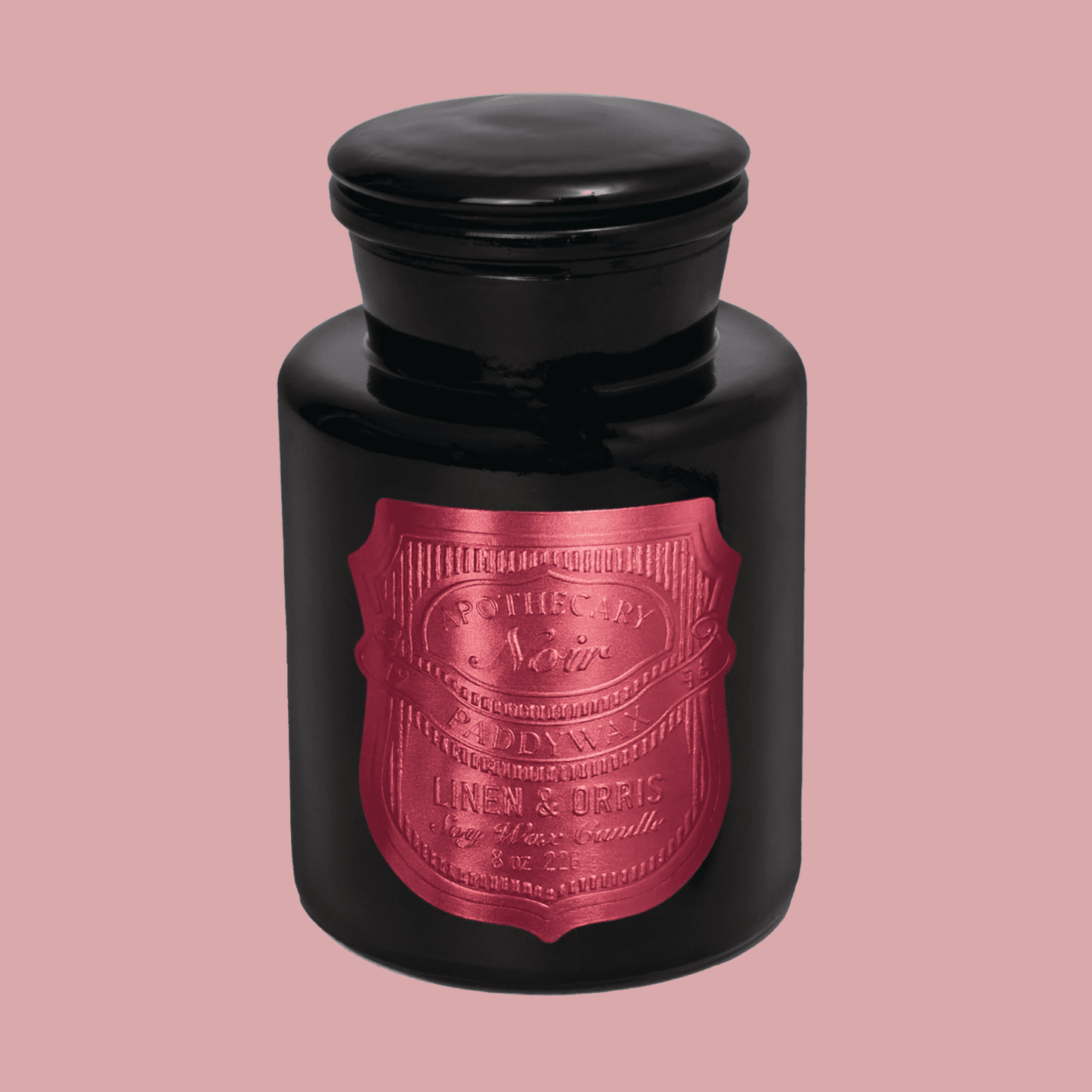 Black candle jar with a hot pink label on a pink background