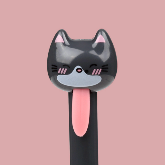 A novelty pen with a cartoon cat face on the top, featuring a black body, pink tongue, and pink inner ears, set against a solid pink background.