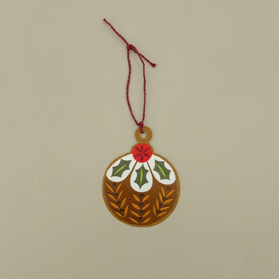 A christmas pudding card gift tag with red twine, on a biege background.