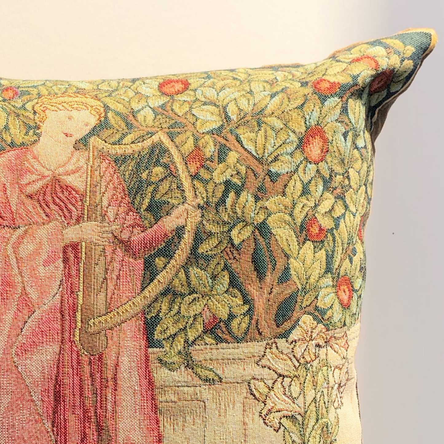 close up of the corner of a woven tapestry cushion displaying a medieval design