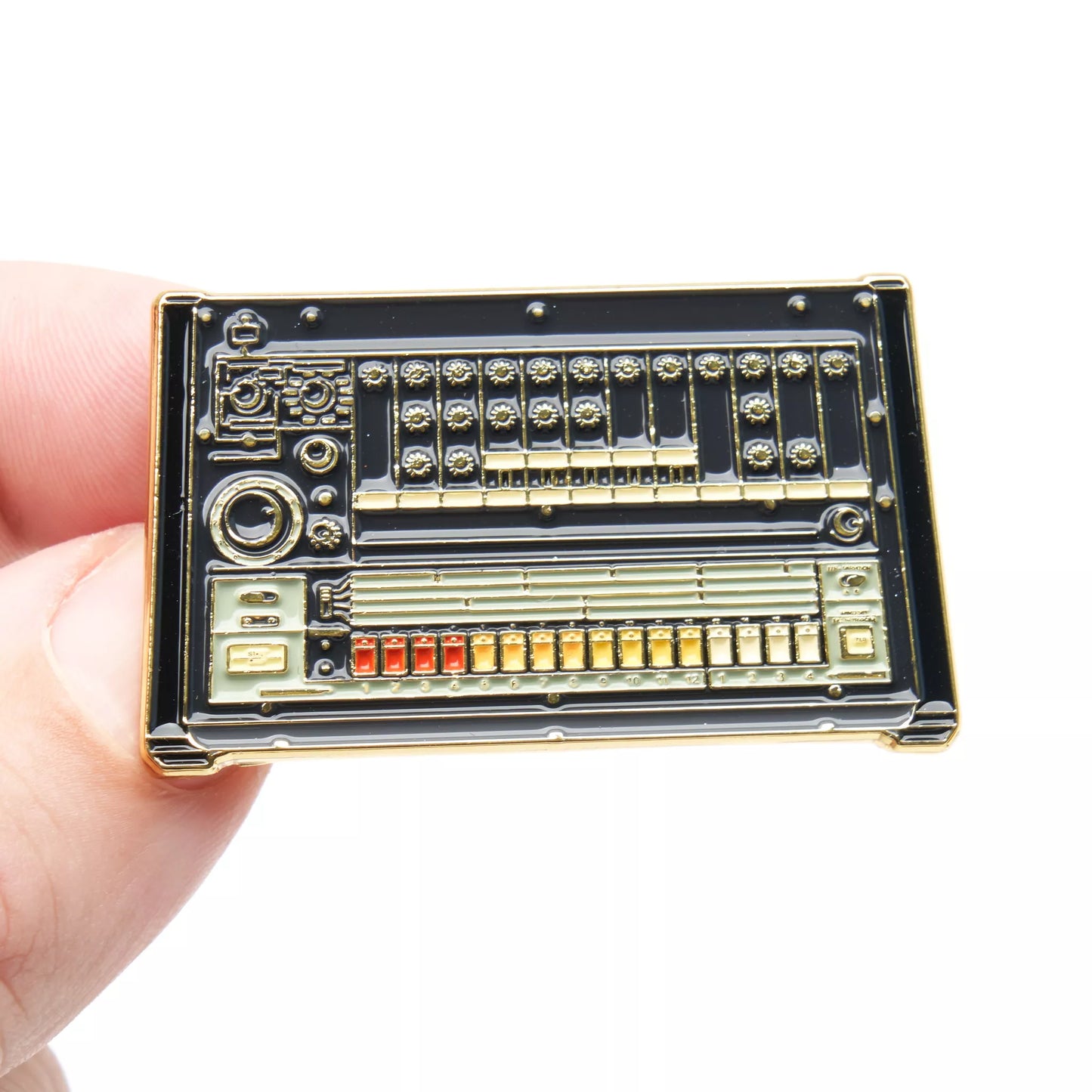 Electronic circuit board pin badge held in a hand against a white background