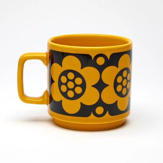Yellow mug with black floral patterns on a white background