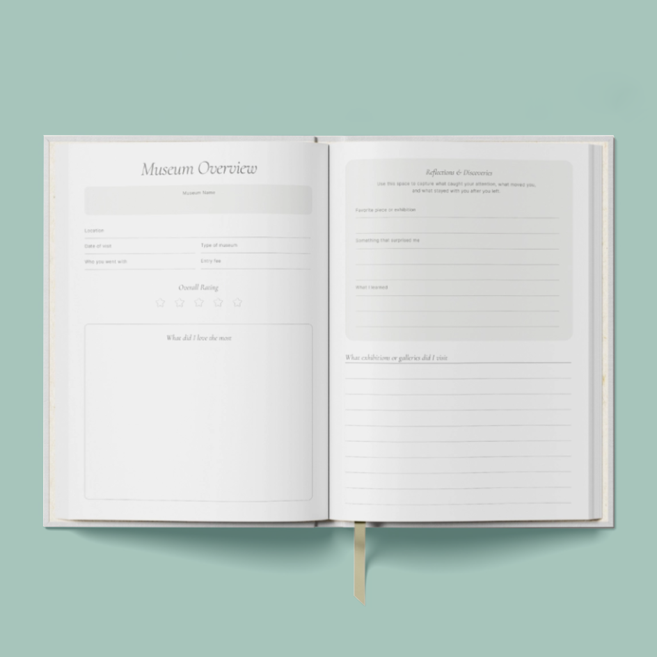 An open book or journal with two blank interior pages laid out like a museum or reflection guide, shown on a solid pale green background. A small gold ribbon bookmark is visible at the bottom center.