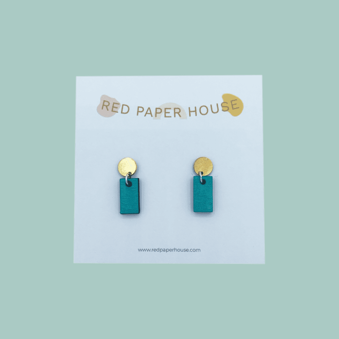 Teal earrings with gold accents on a Red Paper House branded card against a teal background