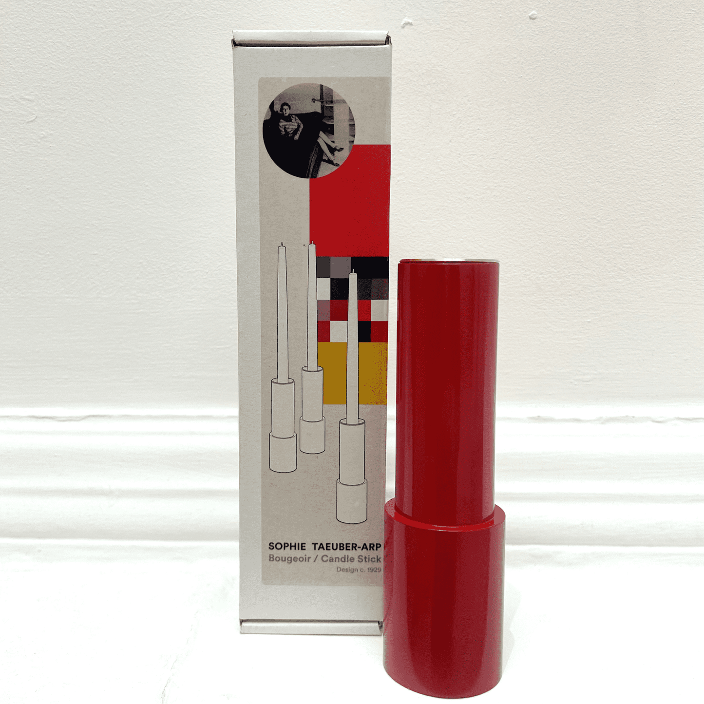 Red candle stick holder with a white box.