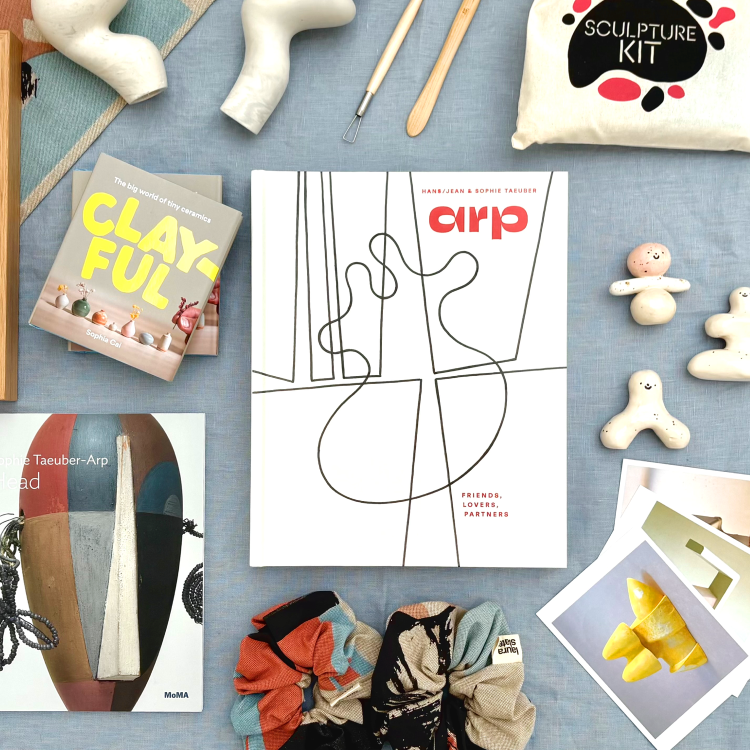 Image with a book of Hans Jean and Sophie Taeuber Arp in the middle, with other sculpture related products on display