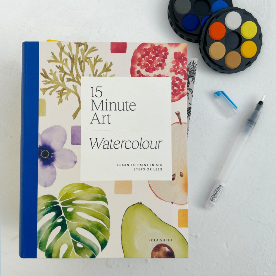 A watercolor painting book titled '15 Minute Art Watercolour' by Jola Soper, styled in a flat-lay with paint palettes and a paint brush on a textured white background.