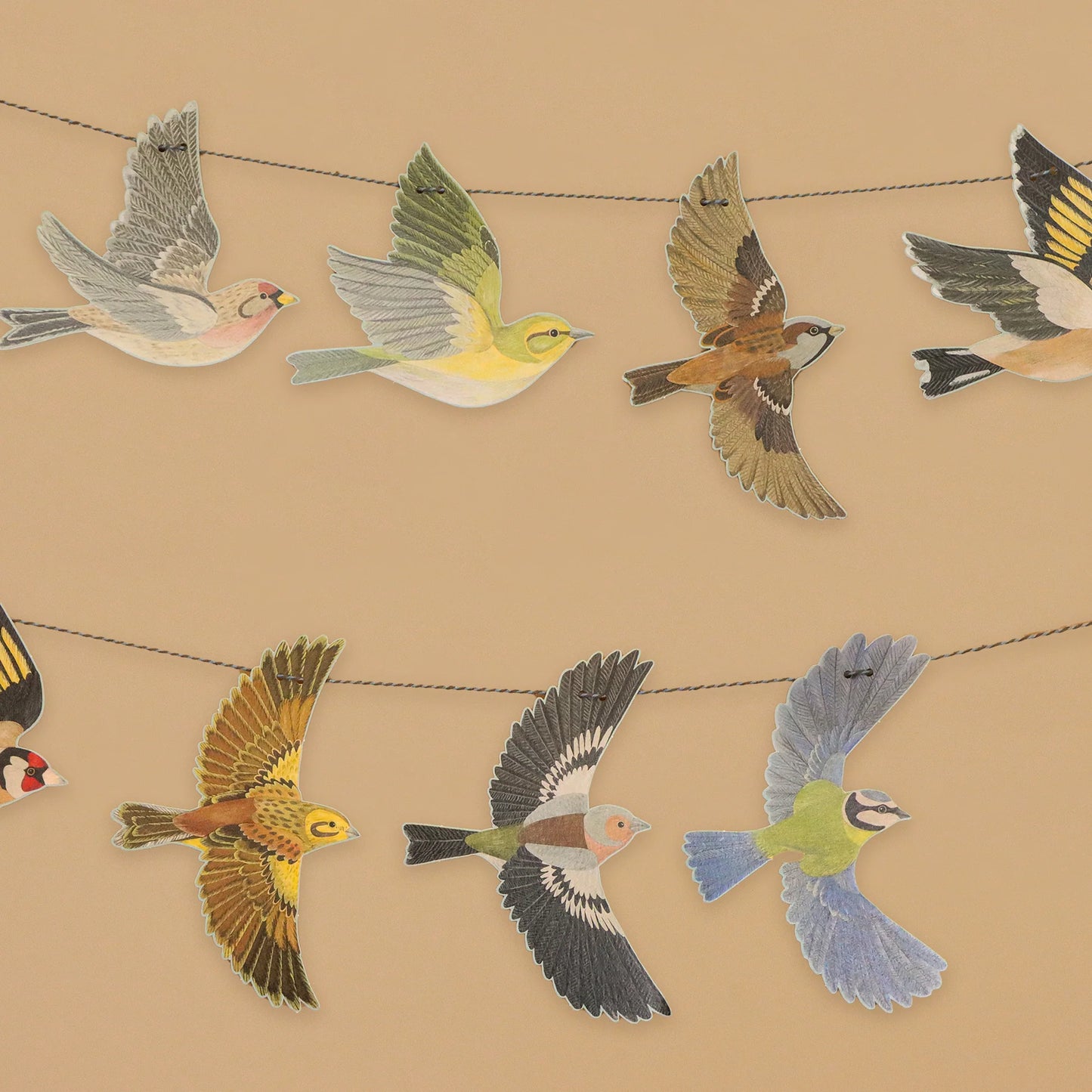 Decorations of various birds hanging on a string garland on a beige background