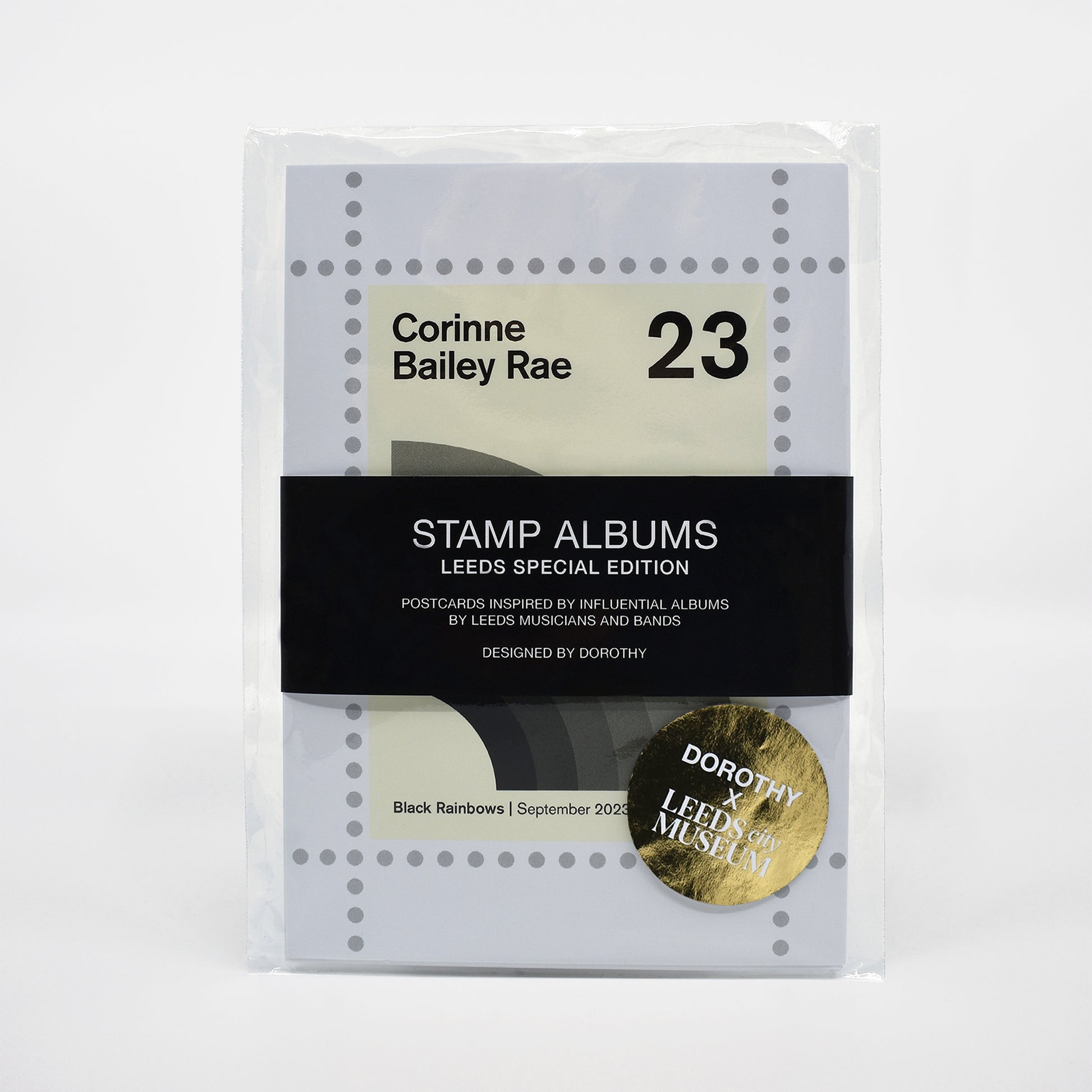 Postcard pack of stamp albums with a gold circular logo on a white background