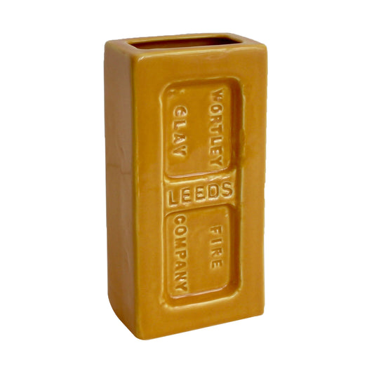 A yellow ceramic brick-shaped vase with 'Wortley Fire Clay Company' embossed on the side.
