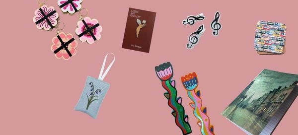 Collection of decorative items including a notebook, bookmarks, and a card on a pink background
