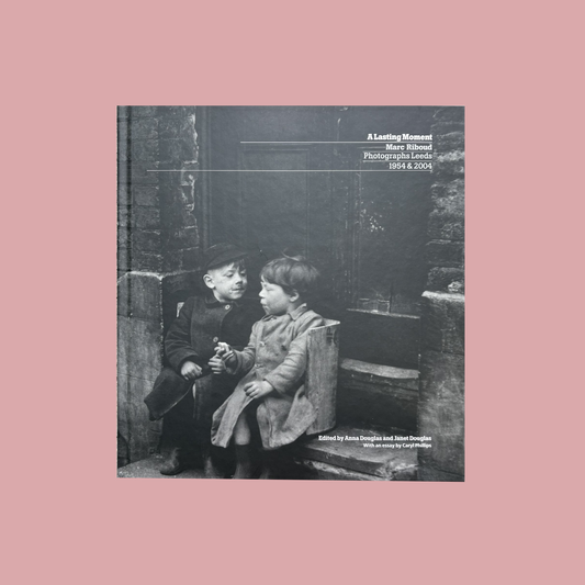 Book cover with black and white photograph of two children sitting on a bench, text overlay.