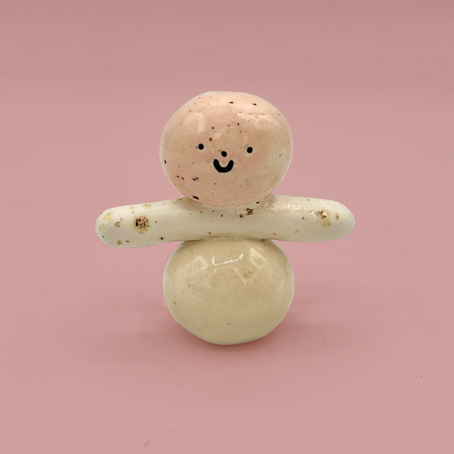 Ceramic figure made of two round objects on a pink background