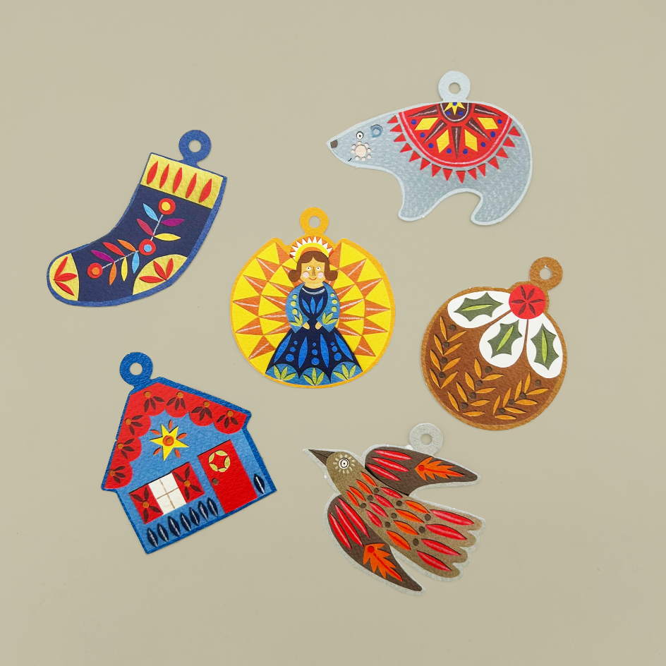 Six colourful Christmas gift tags in traditional folk art styles, arranged on a solid beige background.