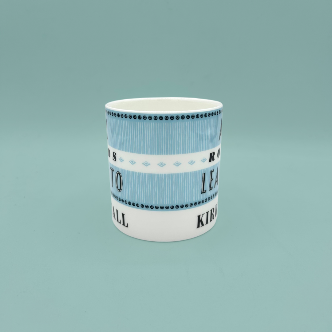 Side profile of a blue and white striped mug, on a teal background.