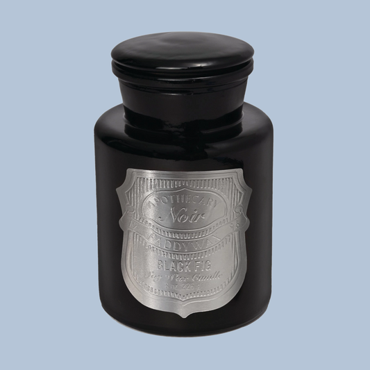 Black candle jar with silver label on a light blue background