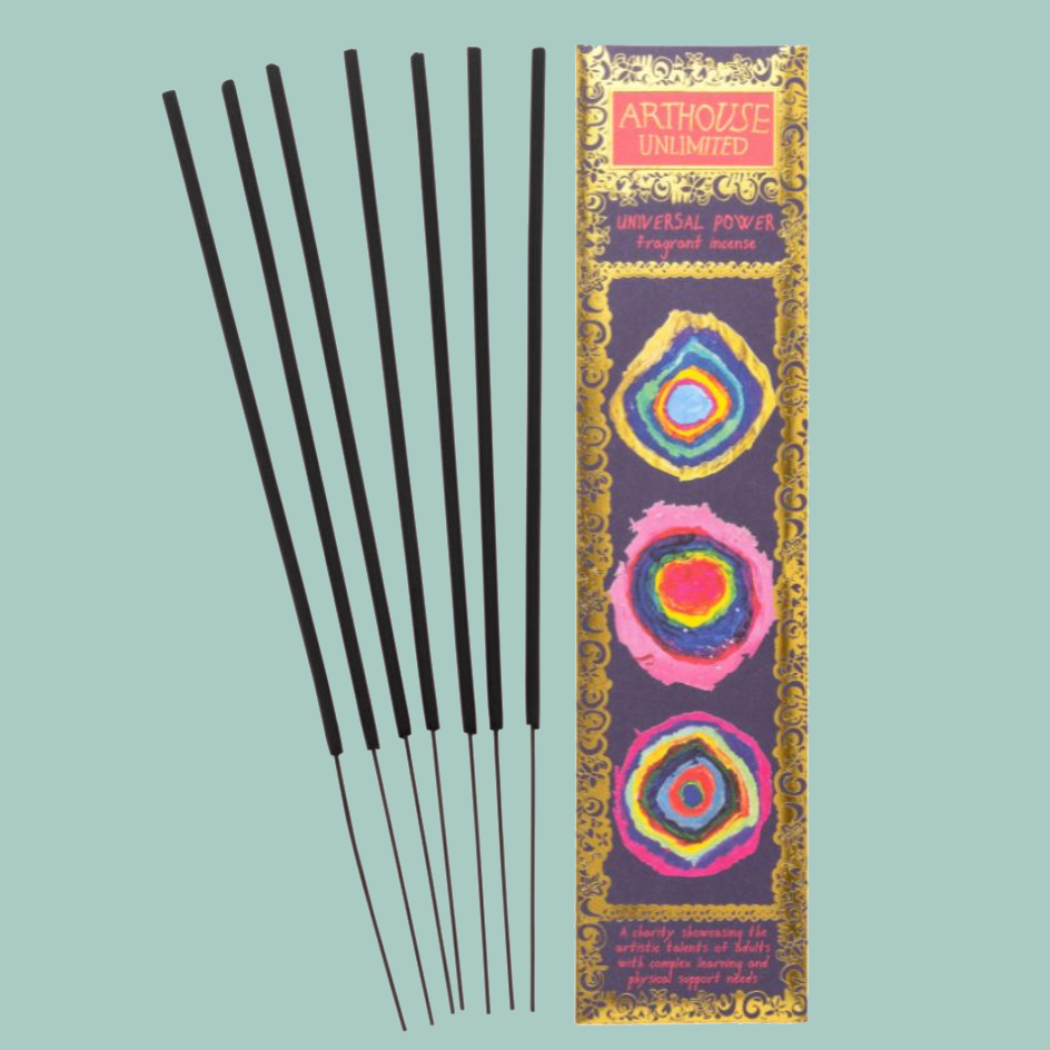 Five black incense sticks next to their decorative packaging by Arthouse Unlimited, set against a solid light teal background.