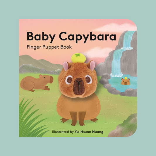 Baby Capybara Finger Puppet Book cover featuring a cute illustrated capybara in a grassy landscape with a waterfall and another capybara resting nearby. The title 'Baby Capybara Finger Puppet Book' is printed at the top, with 'Illustrated by Yu-Hsuan Huang' at the bottom.