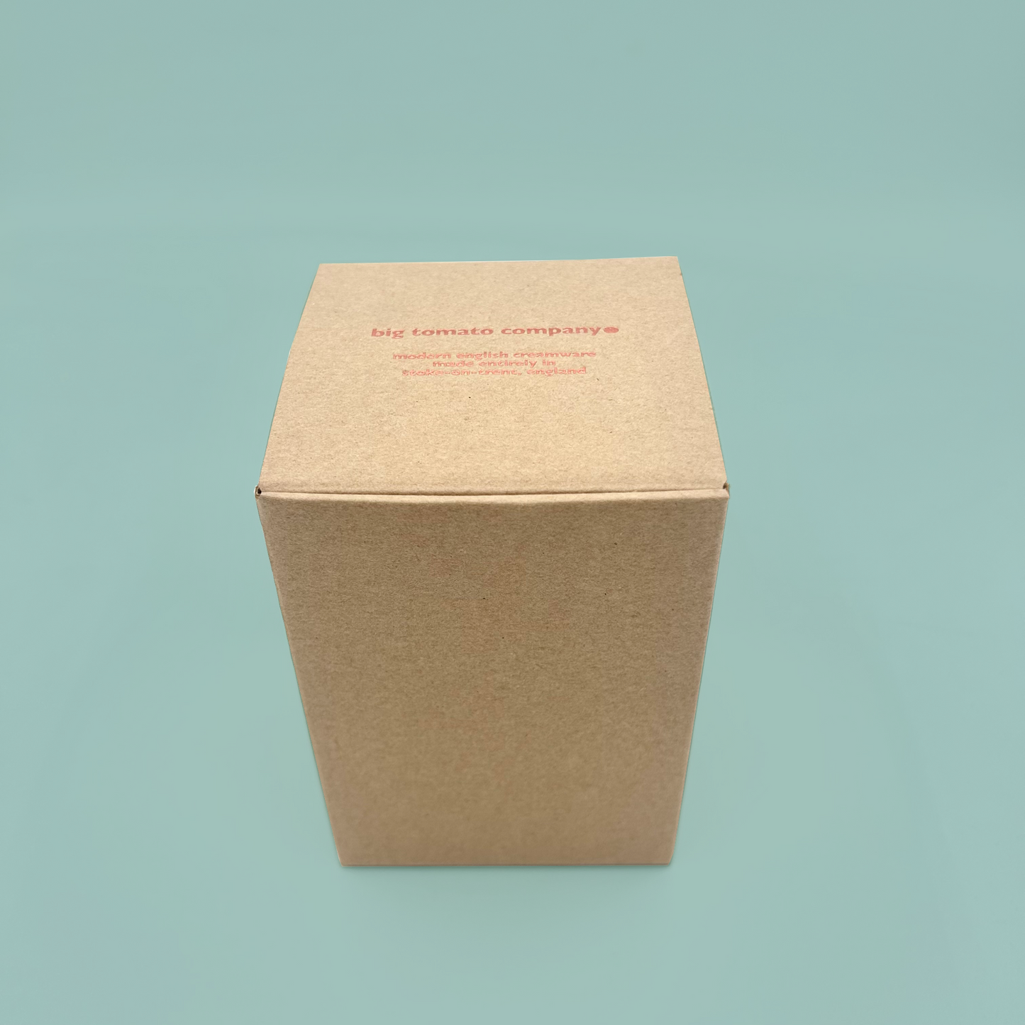 Brown cardboard box with 'big tomato company' text on a light blue background