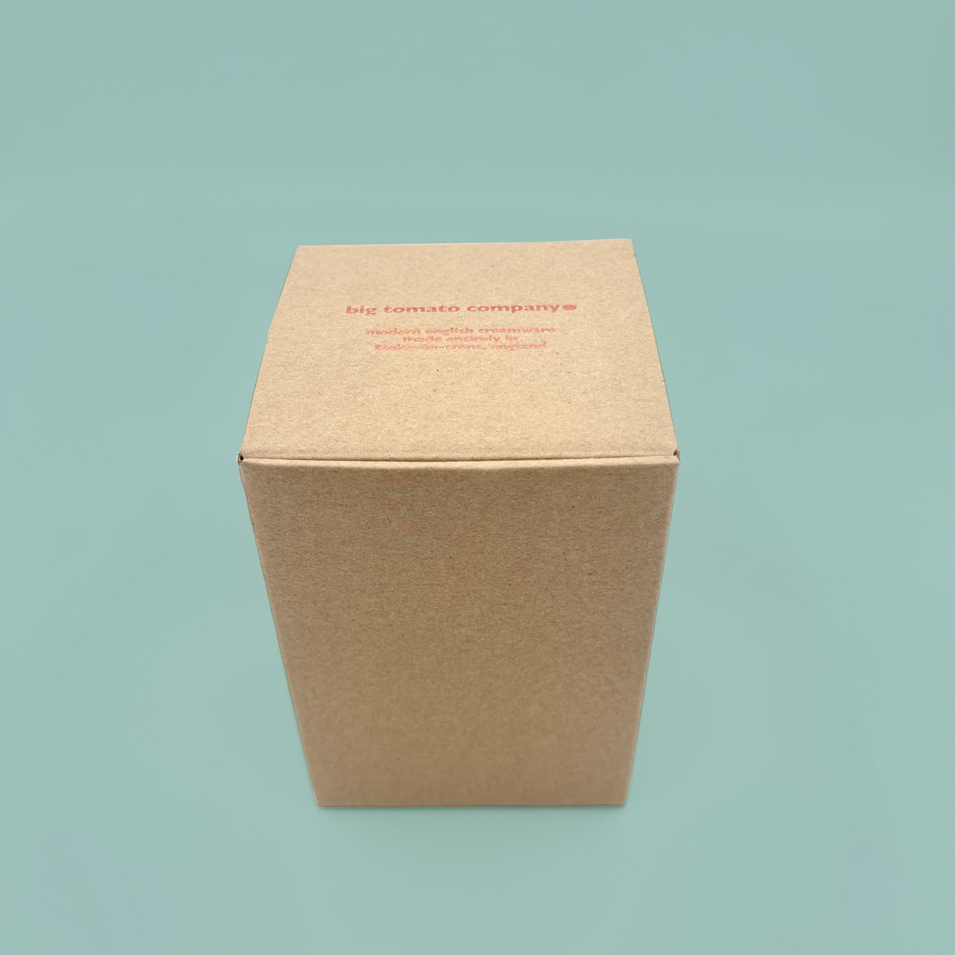 Brown cardboard box with 'big tomato company' text on a light blue background