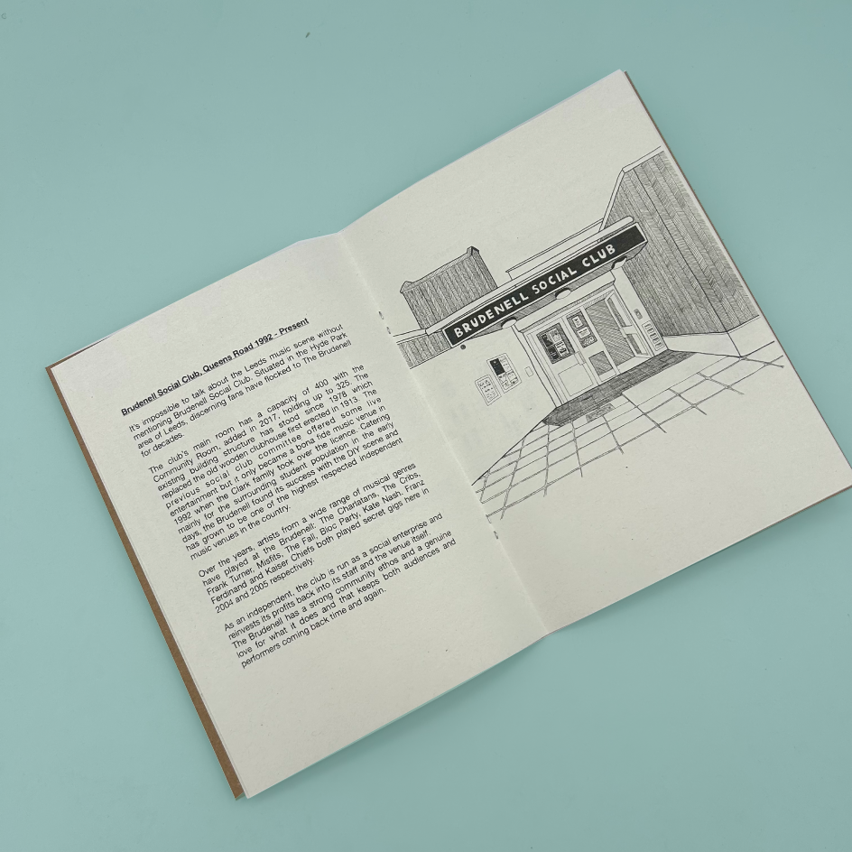 An open zine laid flat on a light blue background. The left page contains printed text about Brudenell Social Club and the right page shows a black-and-white architectural sketch of the beloved working mens club. 