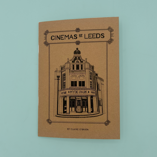 A kraft paper zine cover titled "CINEMAS OF LEEDS" by Claire O'Brien, featuring a black line drawing of a vintage cinema building,  photographed against a light blue backdrop.
