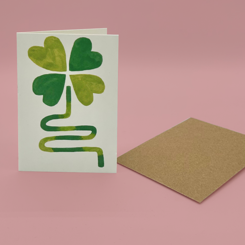 Card with a four-leaf clover design on a pink background
