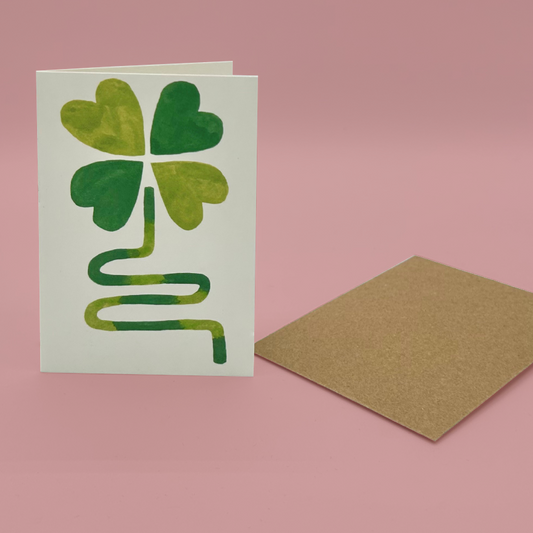 Card with a four-leaf clover design on a pink background