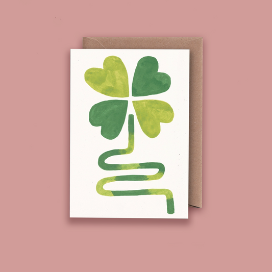 Card with a four-leaf clover design on a pink background