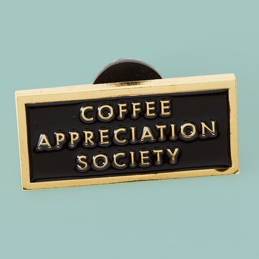 A rectangular enamel pin with a gold border and black face, featuring the words 'COFFEE APPRECIATION SOCIETY' in raised gold lettering, shown on a solid light blue background.