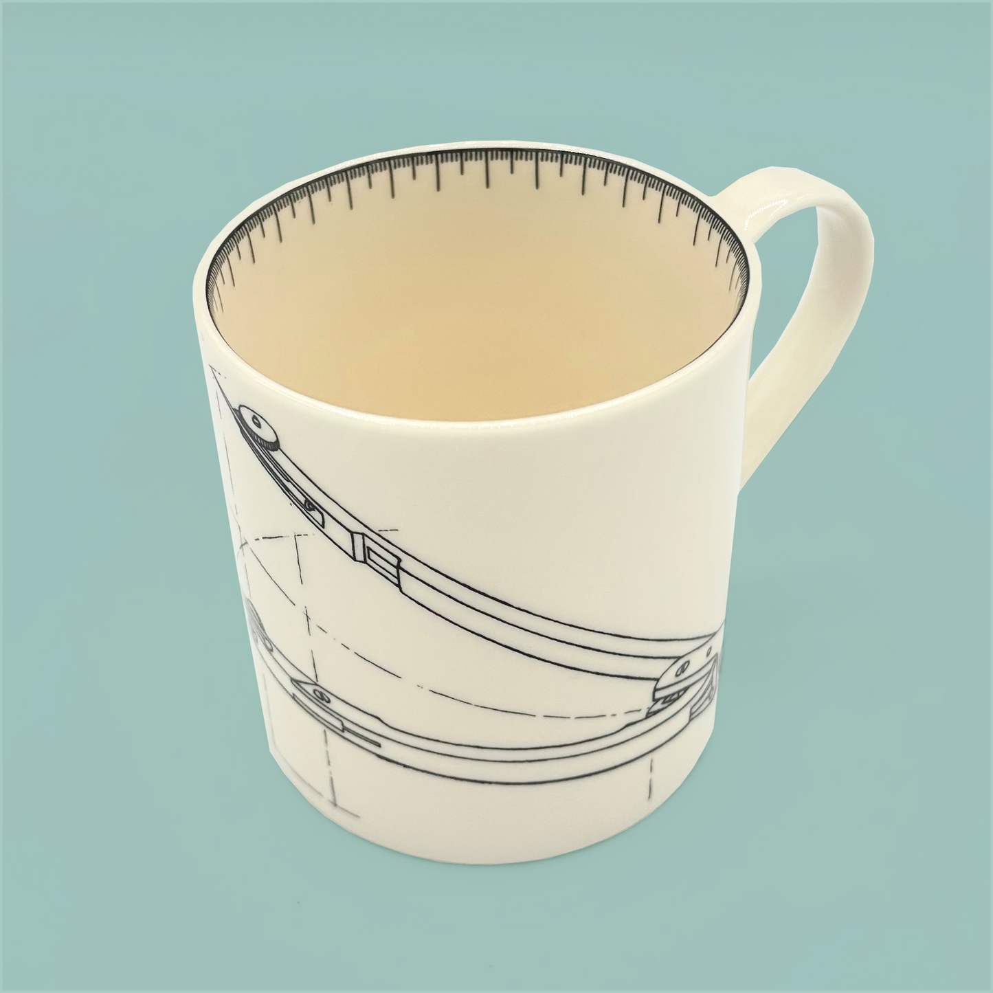 Top view of a white mug with a design of a compass on a light blue background