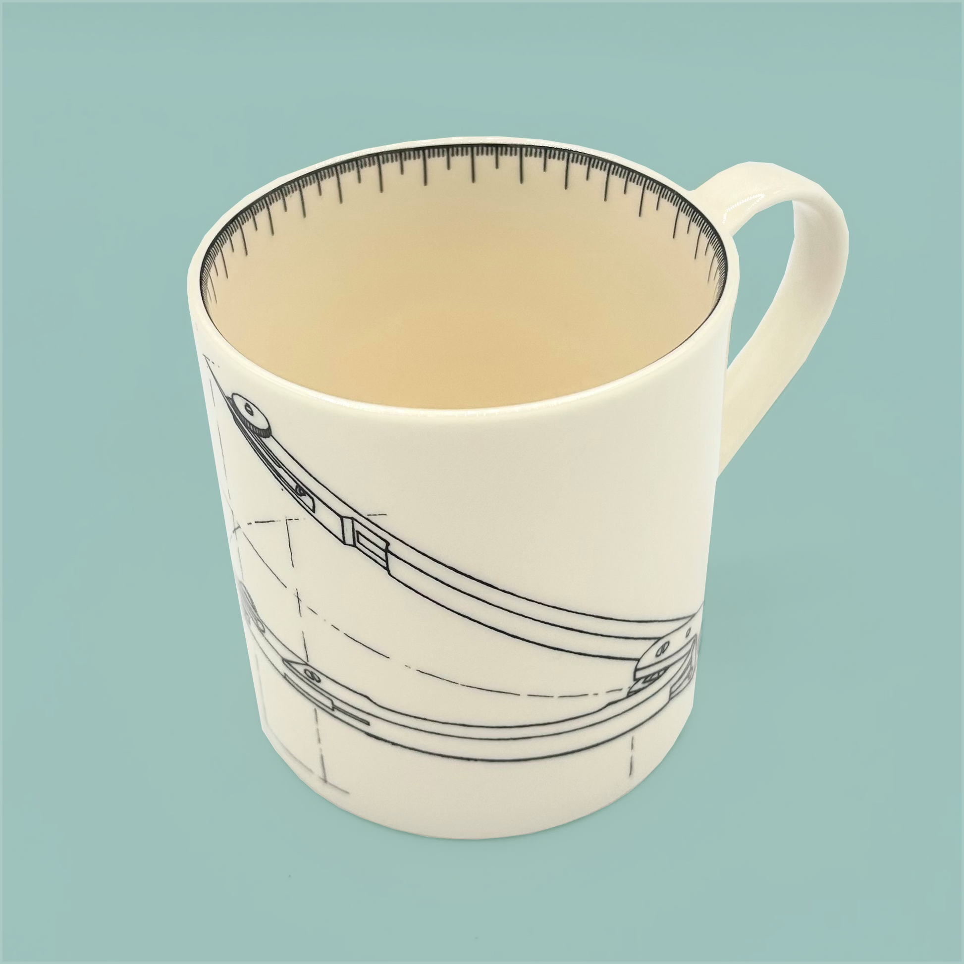 Top view of a white mug with a design of a compass on a light blue background
