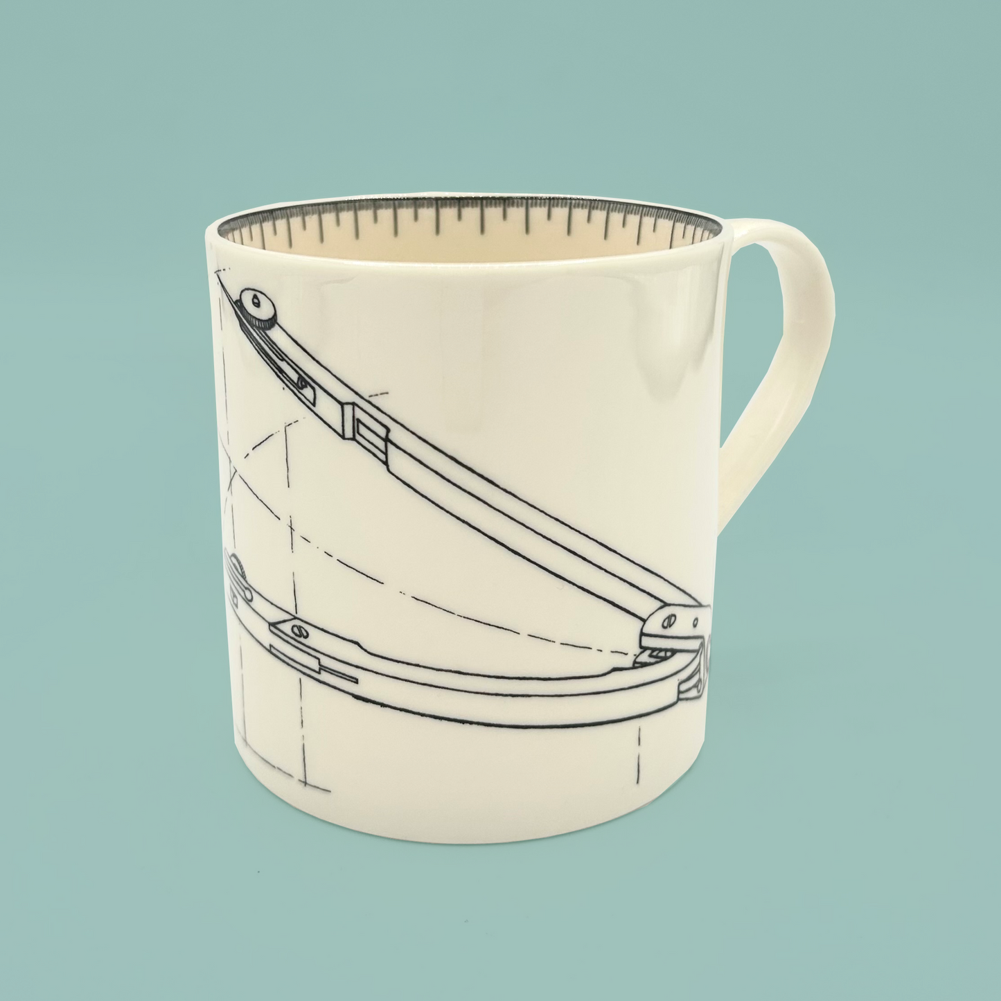 White mug with a design of a compass on a light blue background