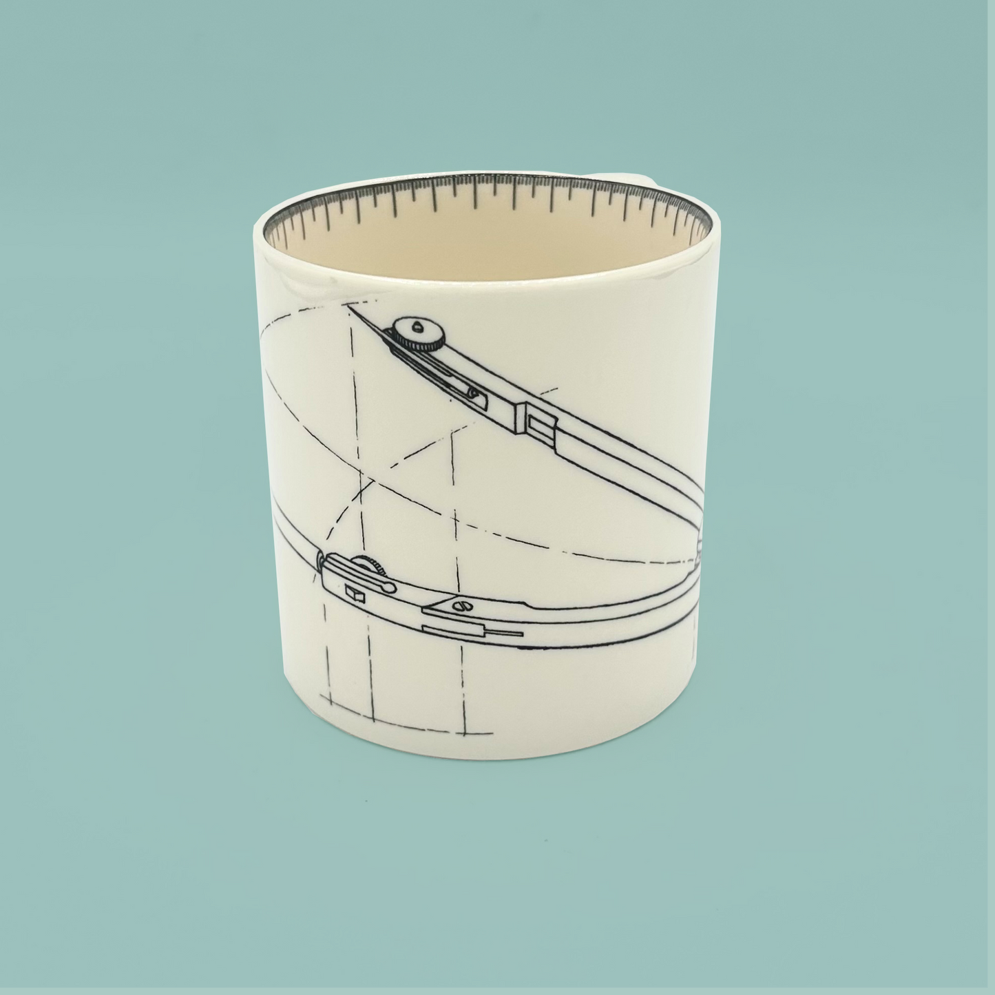 White mug with a design of a compass on a light blue background