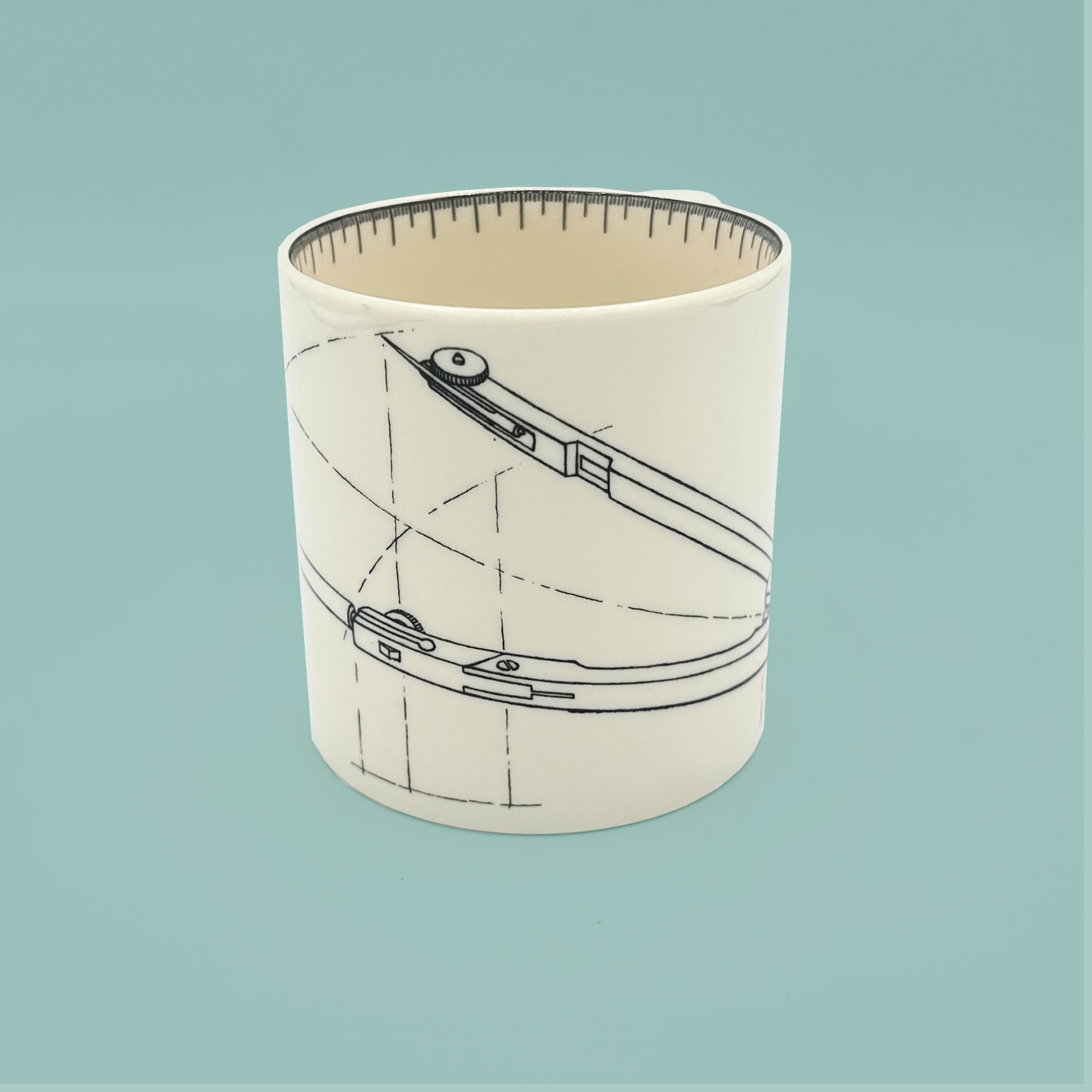 White mug with a design of a compass on a light blue background