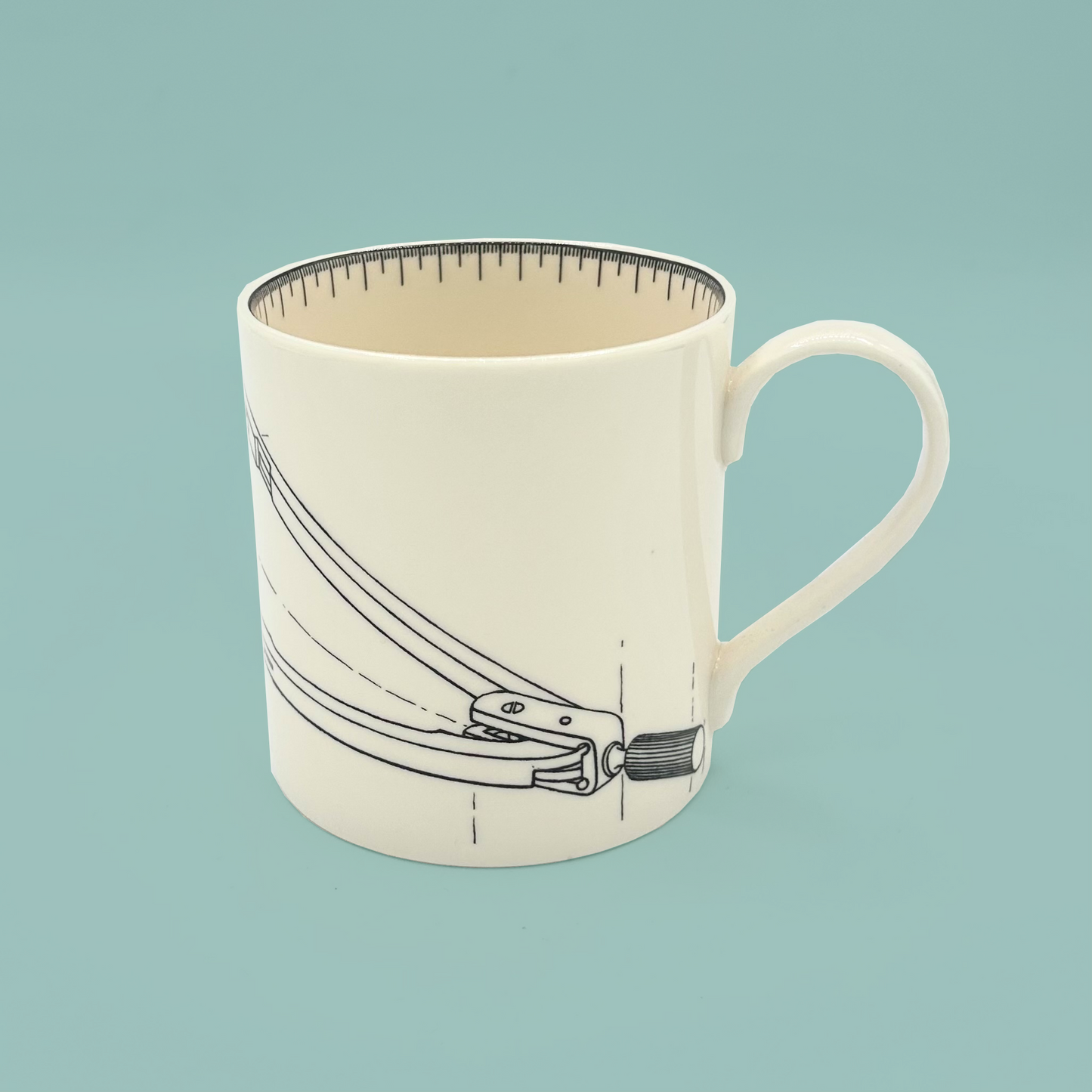 White mug with a design of a compass on a light blue background
