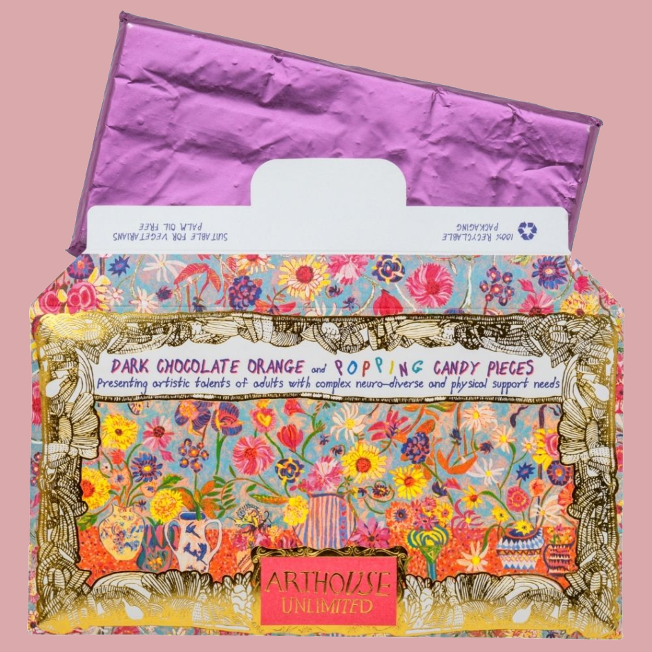 Colourful chocolate bar packaging with a purple foil wrapped bar popping out of the top of the box. The front packaging is covered in dense floral and whimsical illustrations with text reading 'DARK CHOCOLATE ORANGE and POPPING CANDY PIECES' and an 'ARTHOUSE UNLIMITED' label.