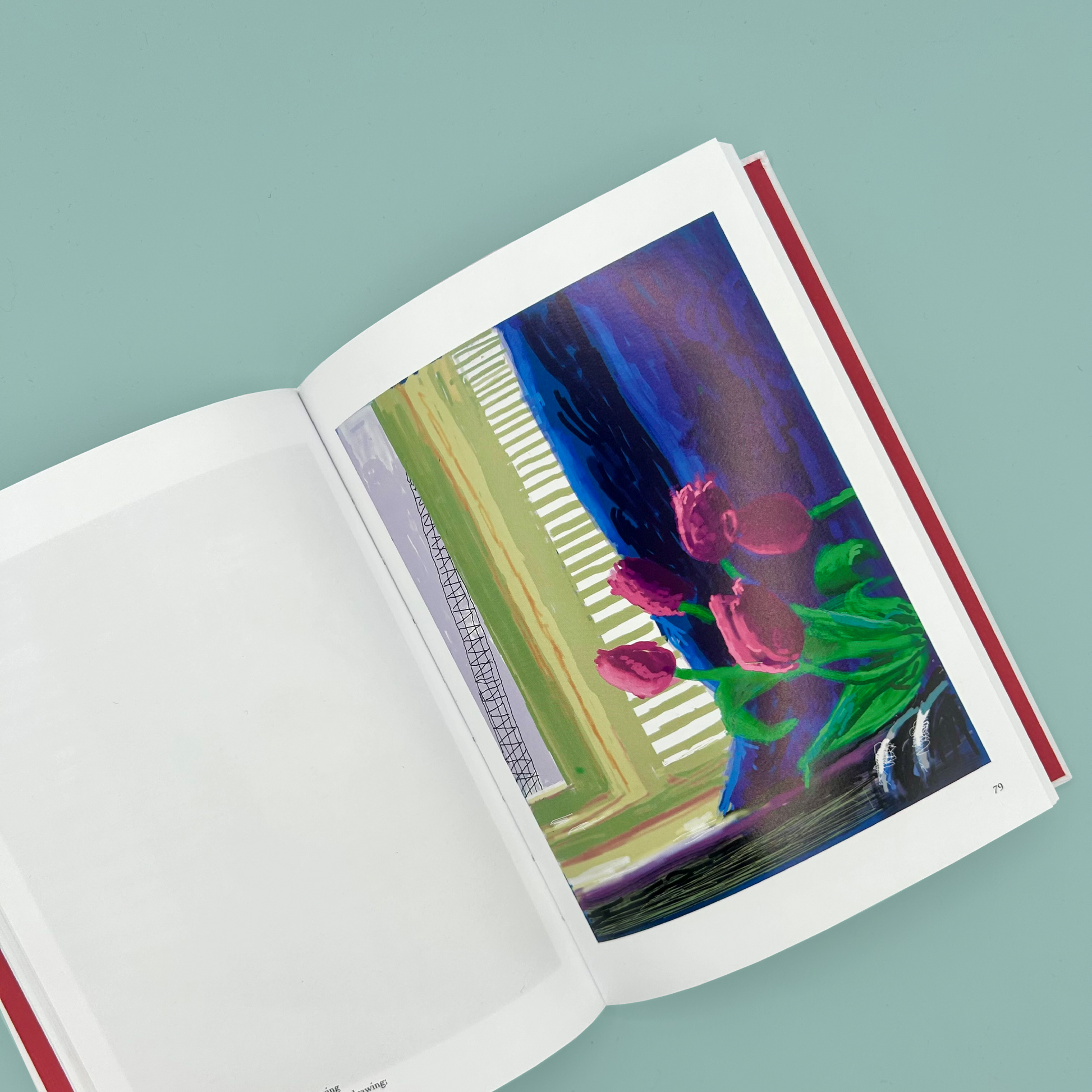 Open book with a colorful ipad painting of flowers on a light blue background