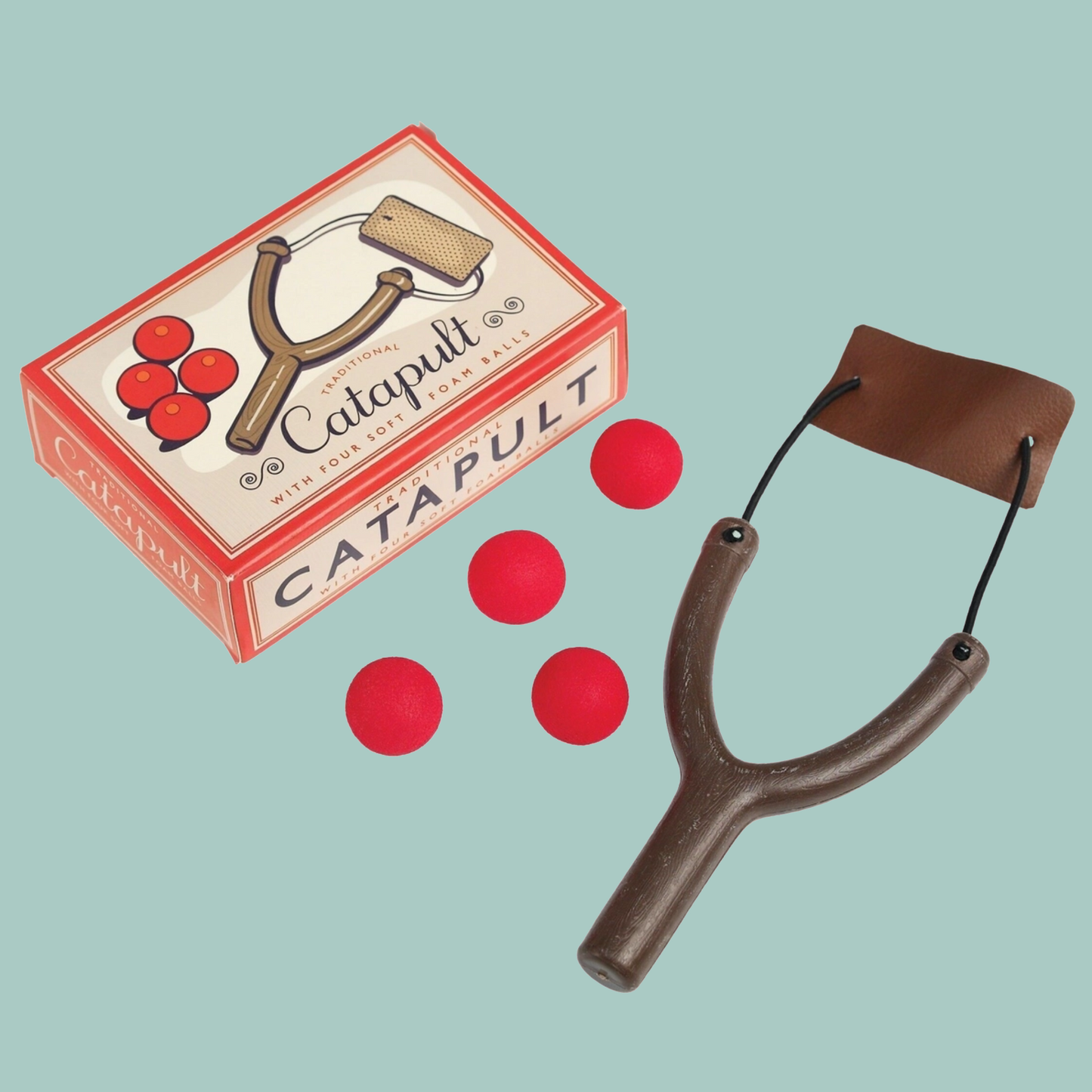 Toy catapult with red balls and packaging on a light blue background
