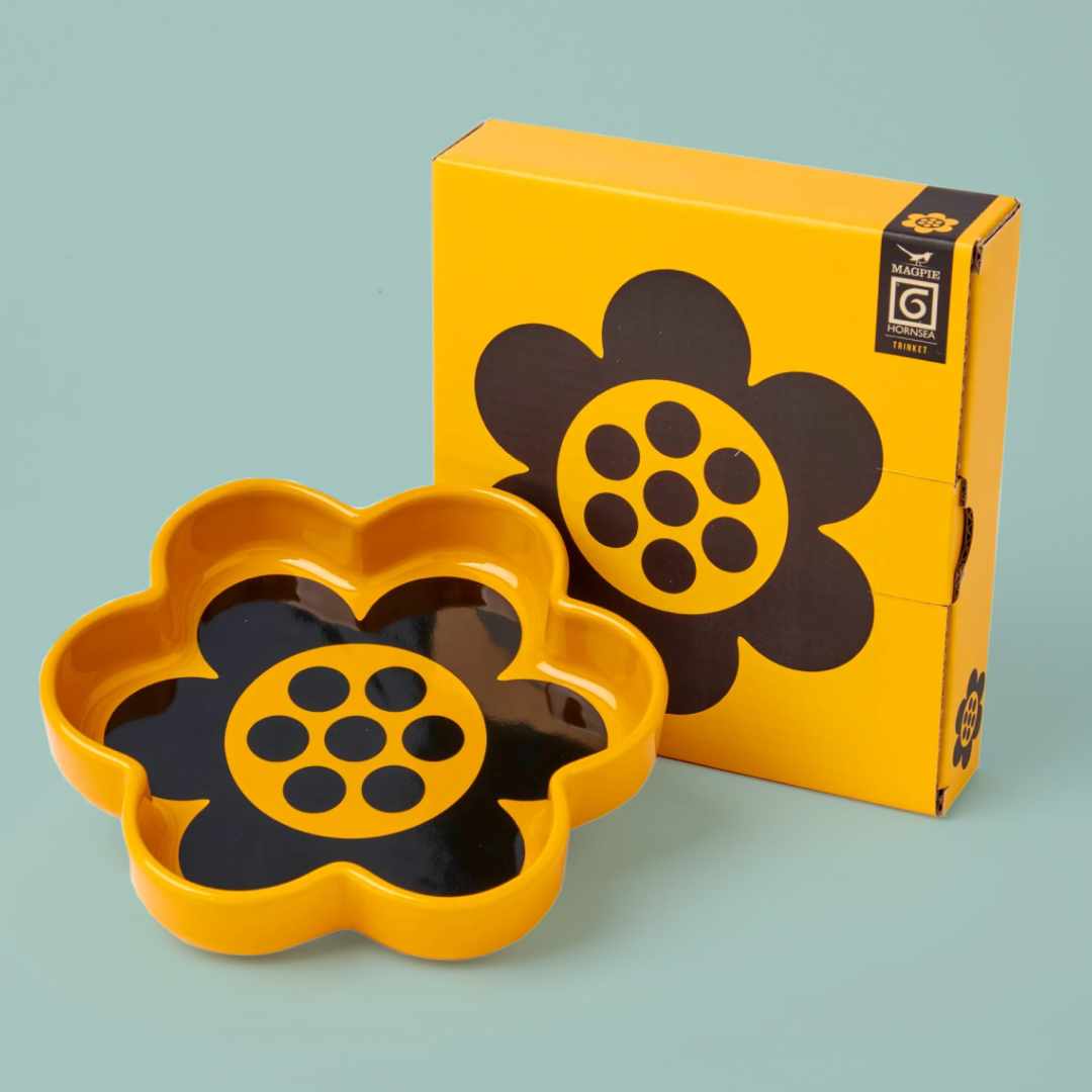 Yellow and black flower-shaped flower with packaging on a light blue background
