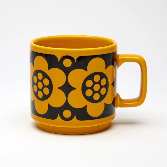 Yellow mug with black floral patterns on a white background