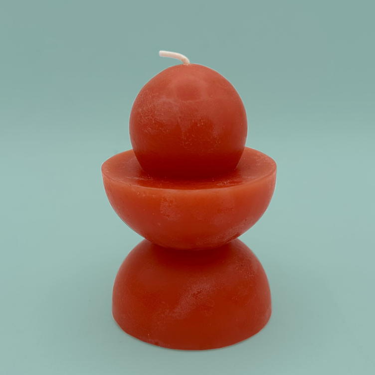 A red candle which is made of stacked semi spheres and a sphere.