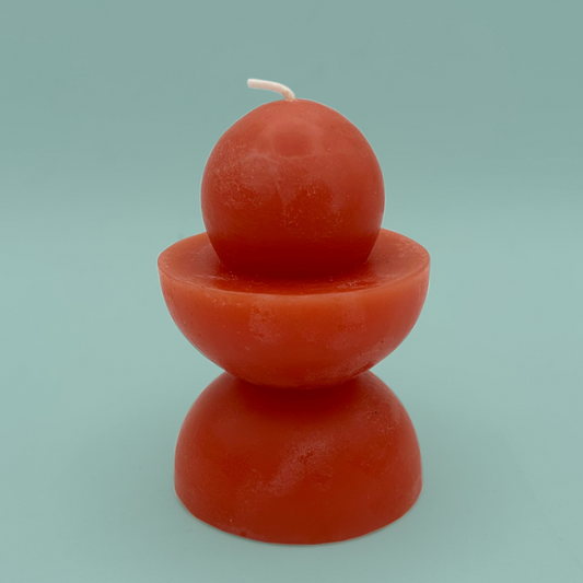 A red candle which is made of stacked semi spheres and a sphere.