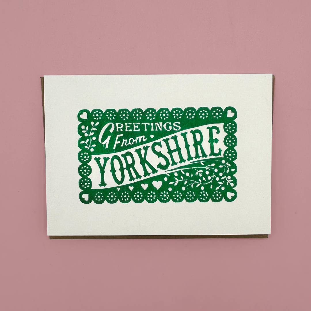 Card with 'Greetings from Yorkshire' text on a pink background