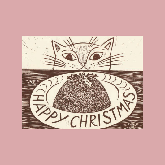 A christmas card featuring a brown line-art illustration of a cat above a plate with a pudding and the words “HAPPY CHRISTMAS,” centered on a dusty pink background.