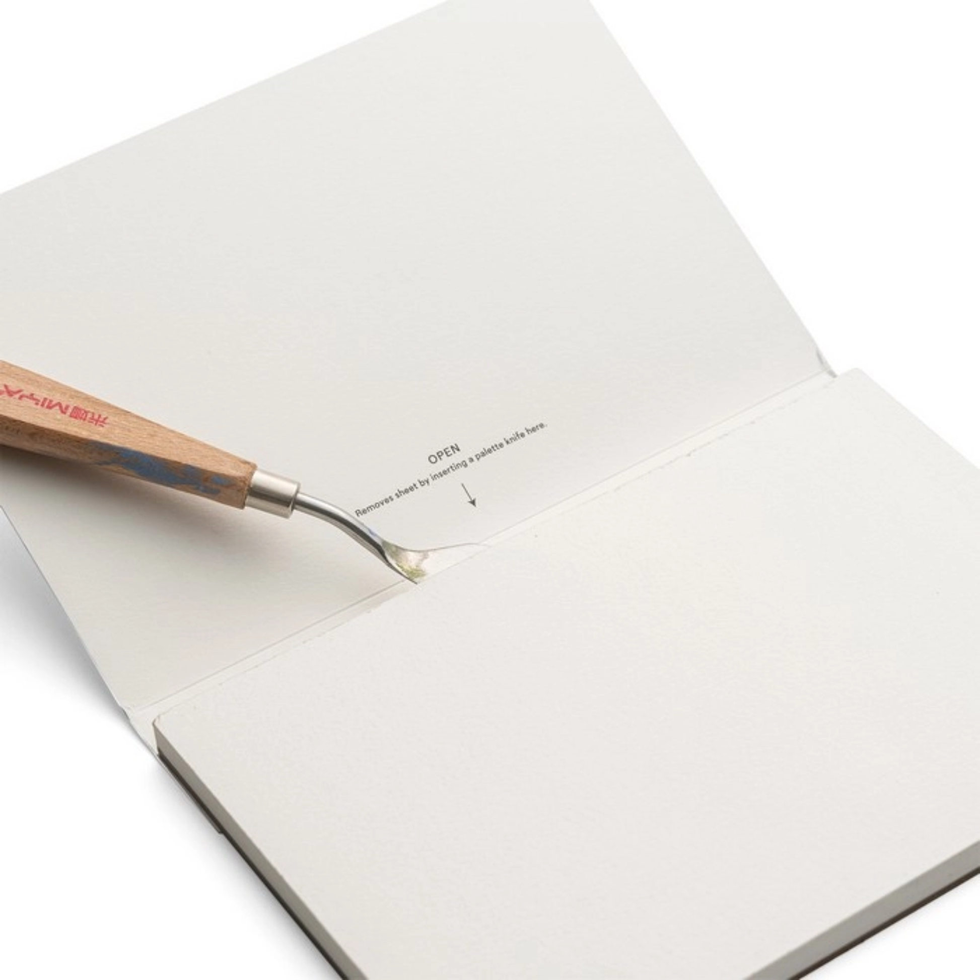 Wooden tool with a metal tip on an open book