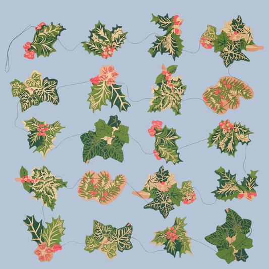 A garland of variegated green and cream holly leaves with small pink berries, arranged in a repeating pattern on a light blue background.