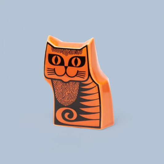 An orange ceramic cat-shaped ornament with black line-art details, set against a solid light blue background.